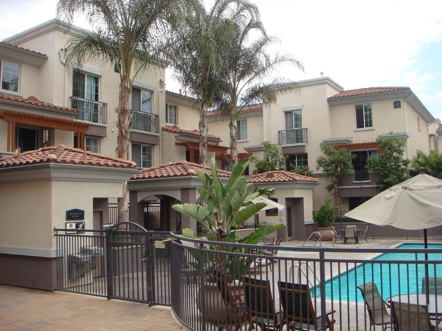 A pool area with chairs and umbrellas next to the pool.