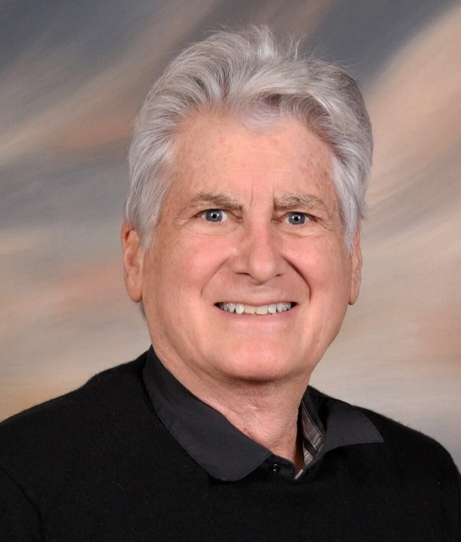 Smiling man with gray hair and black shirt.