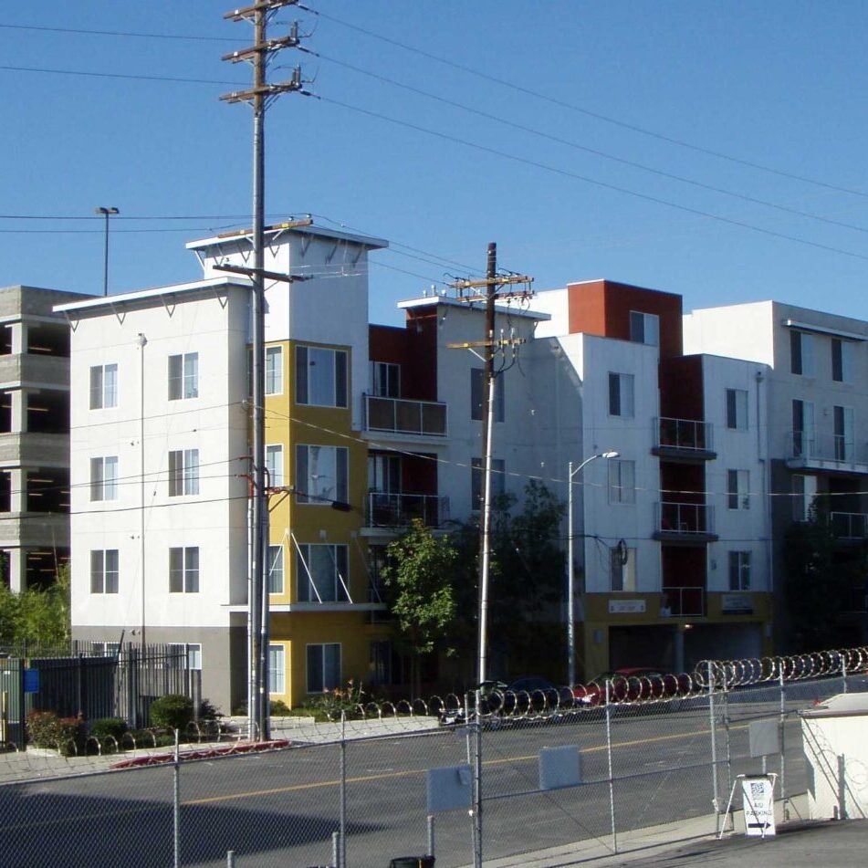 A white building with many windows and a fence